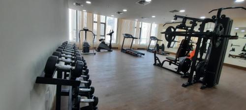 a gym with several tread machines in a room at SIRIUS TOWER in Juffair