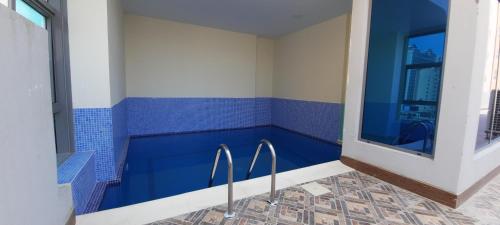 a blue tiled bathroom with tongs in it at SIRIUS TOWER in Juffair