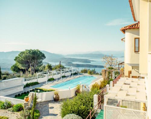 a villa with a swimming pool and mountains in the background at Lagou Raxi Country Hotel in Lafkos