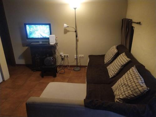 sala de estar con sofá y TV en Ca La Marutxi, en Cantallops