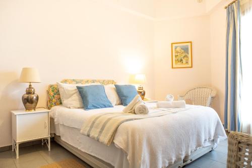 a bedroom with a white bed with blue pillows at Lagou Raxi Country Hotel in Lafkos
