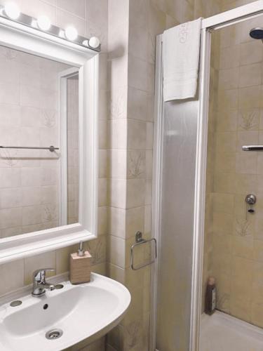 a bathroom with a sink and a shower with a mirror at Praia de Vila do Conde com vista a mar in Vila do Conde