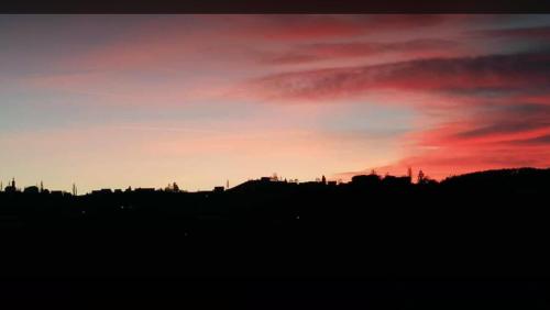 a sunset over a city with a red sky at Wohlmuth-Lückl in Kitzeck im Sausal