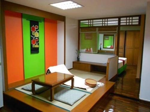a living room with colorful walls and a room with a table at B.S. Court Hotel Sathorn in Bangkok
