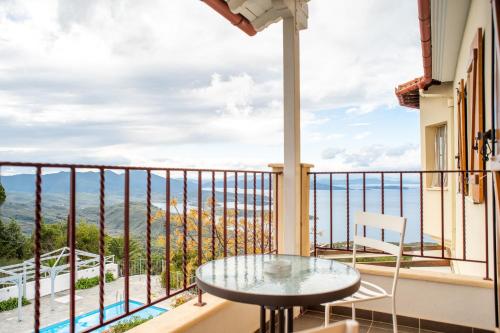 a balcony with a table and a view of the ocean at Lagou Raxi Country Hotel in Lafkos