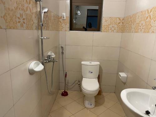 a bathroom with a toilet and a sink at Jaffa Suites in Kampala