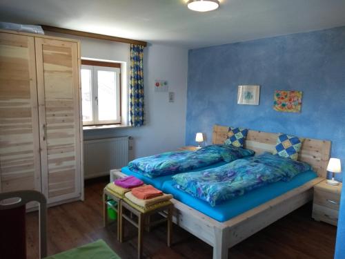 1 dormitorio con cama y pared azul en Landhaus Graßmann en Piding