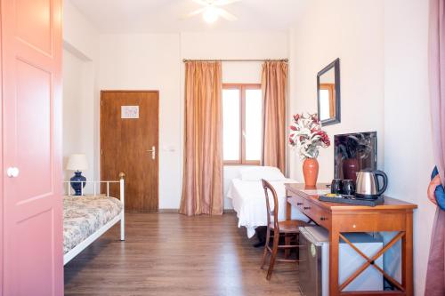 a bedroom with a desk and a bed and a desk sidx sidx sidx at Lagou Raxi Country Hotel in Lafkos