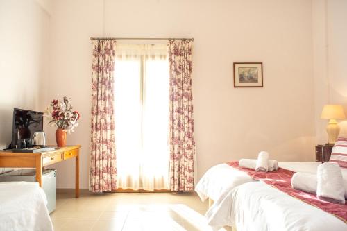 a bedroom with two beds and a window at Lagou Raxi Country Hotel in Lafkos