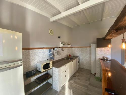 a kitchen with a counter and a microwave in it at Alamo - Casa pet friendly in Olavarría
