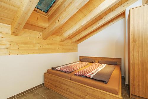 ライト・イム・ヴィンクルにあるHaus Pröchelの木製の天井の客室のベッド1台分です。