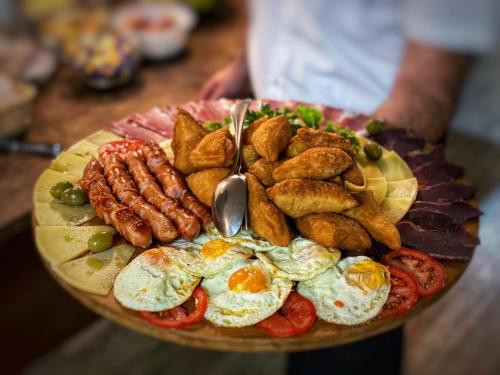 a plate of breakfast food with eggs and other foods at Hotel Turist 98 in Jajce