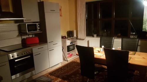 a kitchen with a table and a kitchen with a refrigerator at Monteur- und Ferienwohnung Waldrauschen in Fehrenbach