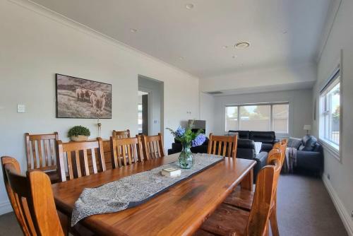 a dining room and living room with a table and chairs at Central Auckland 5-Bedroom Villa with Free Parking in Auckland