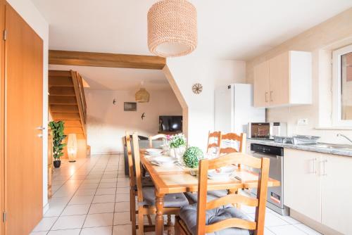 a kitchen and dining room with a wooden table and chairs at Nouveau - La Parenthèse in Wingersheim