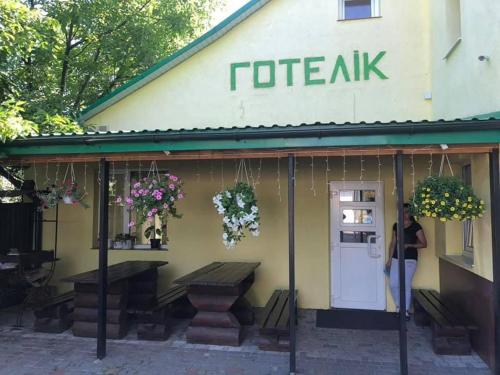 kobieta stojąca przed kawiarnią w obiekcie Готелік w mieście Drohobycz