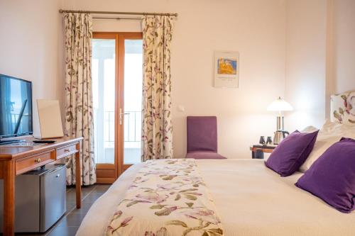 a hotel room with a bed and a television at Lagou Raxi Country Hotel in Lafkos