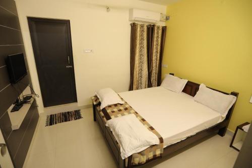 a small bed in a room with a window at Moonlight Residency in Tiruchchirāppalli