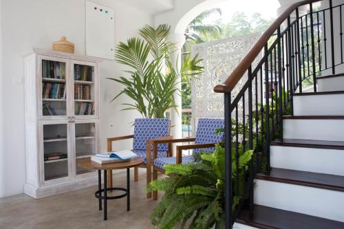 a living room with two chairs and a staircase at Ginger Palm Villa in Hiriketiya