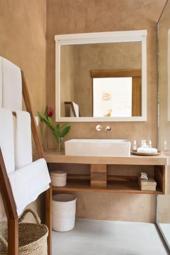 a bathroom with a sink and a mirror at Ginger Palm Villa in Hiriketiya