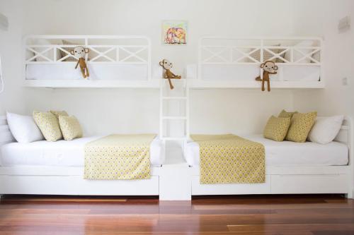 two beds in a room with white shelves at Ginger Palm Villa in Hiriketiya