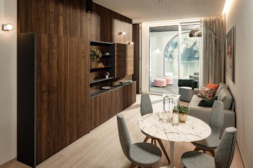 a living room with a table and chairs at ARIA Retreat & SPA - The Leading Hotels of the World, located within Parco San Marco Resort in Porlezza
