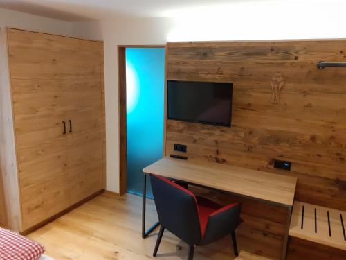a room with a desk and a tv on a wall at Landgasthof Lusenblick in Grafenau