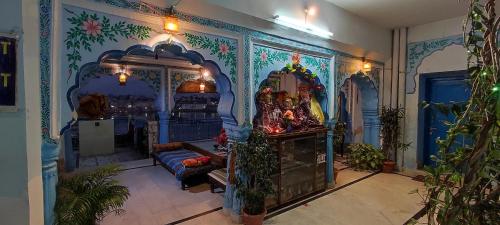 a room with a room with a wall with paintings at Hotel Bharatpur Palace in Pushkar