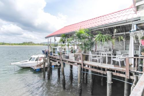 um barco está ancorado numa doca com uma casa em BOHO Hostel em Ko Lanta