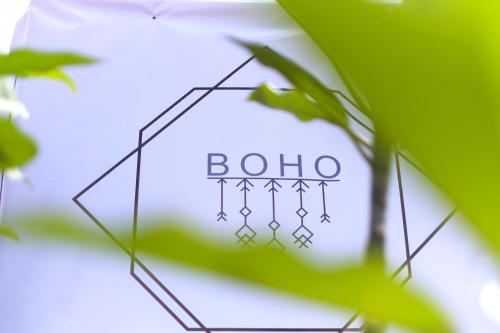 a sign with the word bolo is seen behind a plant at BOHO Hostel in Ko Lanta