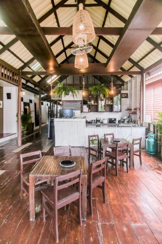 a dining room with wooden tables and chairs at BOHO Hostel in Ko Lanta