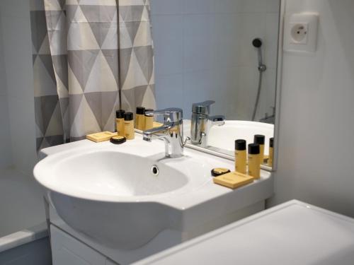 une salle de bain avec un lavabo blanc et un miroir dans l'établissement Cottage du Phare, 3 chambres & jardin, classé 3 étoiles, à Cayeux-sur-Mer