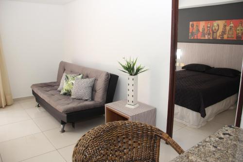 Una sala de estar con un sofá y un espejo. en Marinas Flat Largo de Tambaú, en João Pessoa