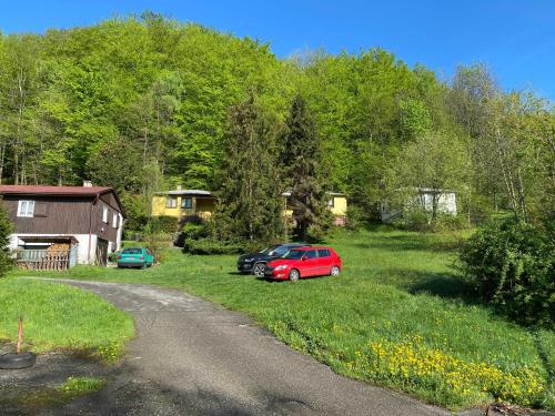 two cars parked in a yard next to a house at Chaty Pod Javorovým in Třinec
