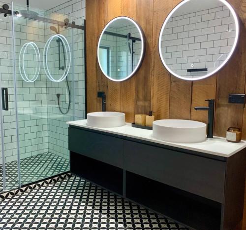 a bathroom with two sinks and two mirrors at Lakeview Oasis in Queenstown