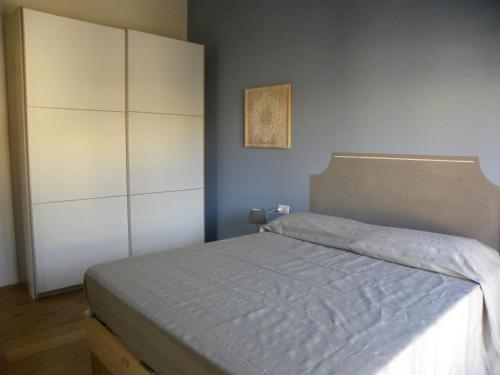 a bedroom with a bed and a white cabinet at Petra Magica in San Pantaleo