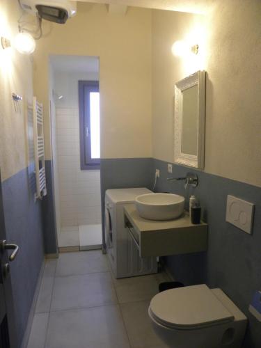 a bathroom with a toilet and a sink at Petra Magica in San Pantaleo
