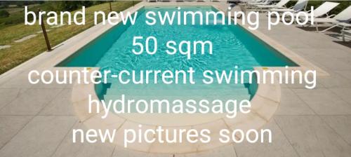 科爾蒙斯的住宿－Al Benandant，一个游泳池,上面有单词,全新的游泳池柜台,正在游泳,新