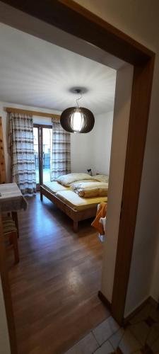 a bedroom with a bed and a chandelier at Hof am Brunnen in Cornaiano
