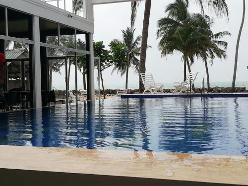 a swimming pool next to a resort with palm trees at Saara Beach Hotel in Marawila