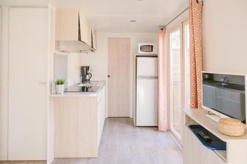a small kitchen with a sink and a refrigerator at Naturéo in Seignosse