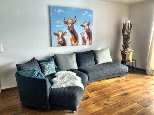 a living room with a couch and a painting on the wall at Apartment Bellania in Davos