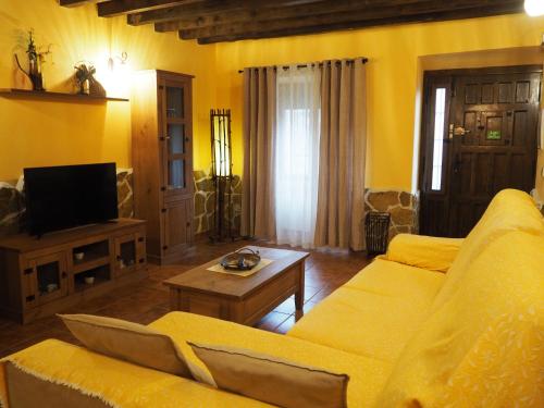 a living room with a couch and a tv at El Rincón de Anter C in Cenicientos