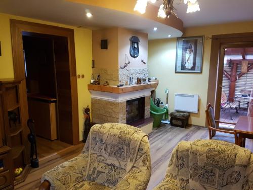a living room with two chairs and a fireplace at PRIVAT FAMILY MALA FATRA in Chmelince
