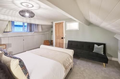 a bedroom with a bed and a black couch at Host & Stay - Sleepers @ No.8 in Pickering