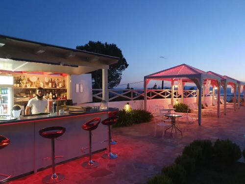 a bar with stools in a patio at night at Lagou Raxi Country Hotel in Lafkos