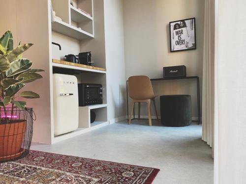 um quarto com um frigorífico e uma secretária com uma cadeira em Home8 studio’s em Arnhem