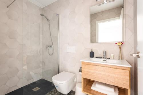 La salle de bains est pourvue de toilettes, d'une douche et d'un lavabo. dans l'établissement Villa La Plaza, à Fornells