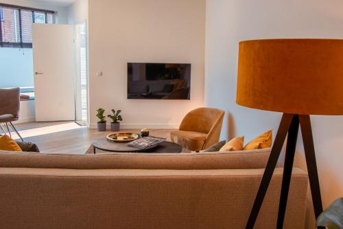 a living room with a couch and a lamp at Boutique Suites Deluxe in Middelburg