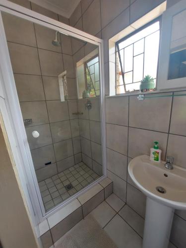 a bathroom with a shower and a sink at DeLutz Overnight Room 3 in Polokwane